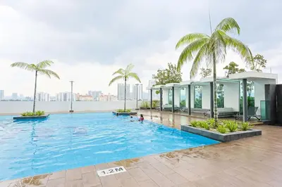 a large swimming pool with palm trees and a building at One Maxim Sentul By LuxeStay in Kuala Lumpur