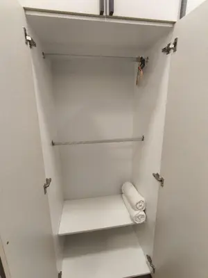 a white closet with a towel on a shelf at Luxe Colony By Urban Haven in Kuala Lumpur
