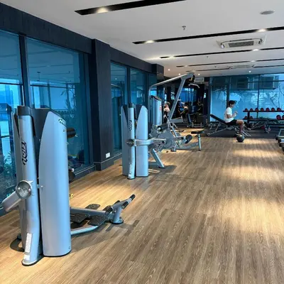 a gym with tread machines and people in the background at Luxe Colony By Urban Haven in Kuala Lumpur