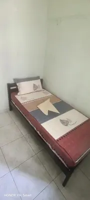 a small bed in a corner of a room at Hot Spring Residential in Kuala Lumpur