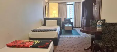 a hotel room with two beds and a table and a chair at Times square in Kuala Lumpur