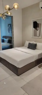 a bedroom with a large bed with white sheets at City Suites At Quill Residence KL in Kuala Lumpur