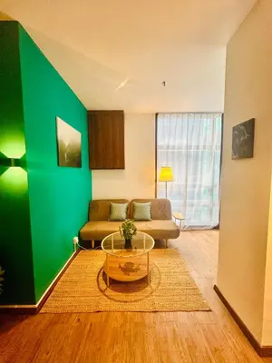 a living room with a couch and a green wall at Premium One Bedroom Condo at Bangsar Trade Centre in Kuala Lumpur