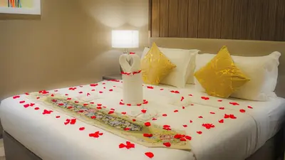 a bed with red rose petals on it at Imperial Residences KLCC - JD World Homestay in Kuala Lumpur