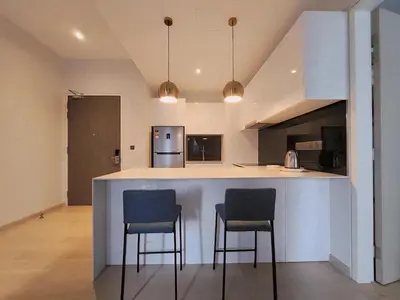 a kitchen with two bar stools and a counter top at Trion KL Skyline Suites in Kuala Lumpur