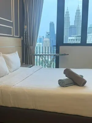 a bed in a hotel room with a view of a city at The Wisma INFINITUM BY KL in Kuala Lumpur