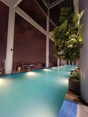a swimming pool at night with a view of a city at The Wisma INFINITUM BY KL in Kuala Lumpur
