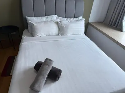 a bed with two towels sitting on top of it at The Wisma INFINITUM BY KL in Kuala Lumpur