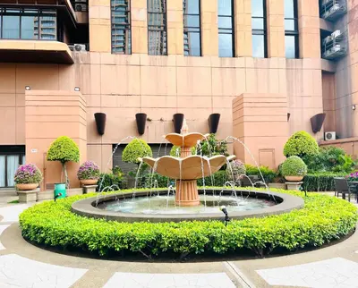 a fountain in a courtyard in front of a building at Max suites in Kuala Lumpur