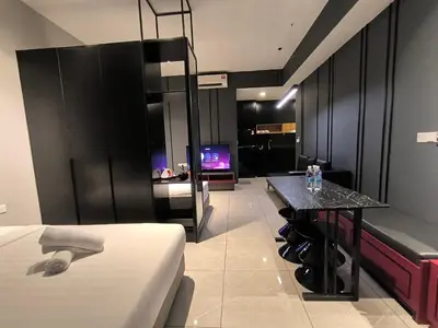 a room with a bed and a table and a tv at The Bukit Bintang Near pavilion Axon Residence KL in Kuala Lumpur