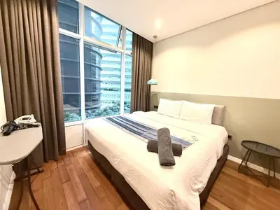 a bedroom with a bed and a large window at sky suites klcc by Natasya in Kuala Lumpur