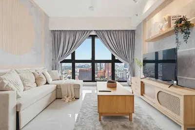 a living room with a white couch and a large window at Earthy 2BR @ Agile BB | Wi-Fi + Netflix in Kuala Lumpur