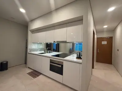 a kitchen with white cabinets and a stove top oven at Sky Suits By White Houze in Kuala Lumpur