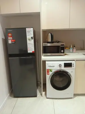 a kitchen with a microwave and a washing machine at Quill Residence relax Suites KLCC in Kuala Lumpur