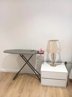 a table with a lamp and a white nightstand at Quill Residence relax Suites KLCC in Kuala Lumpur