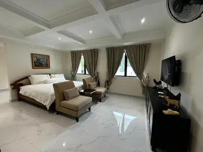 a bedroom with a bed and a chair and a television at My Kamar Kamar in Kuala Lumpur
