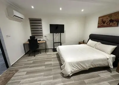 a bedroom with a bed and a desk with a computer at My Kamar Kamar in Kuala Lumpur