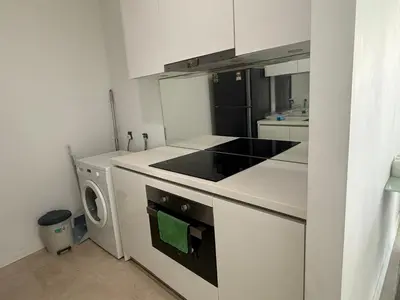 a kitchen with a stove top oven next to a washing machine at Vortex KLCC in Kuala Lumpur
