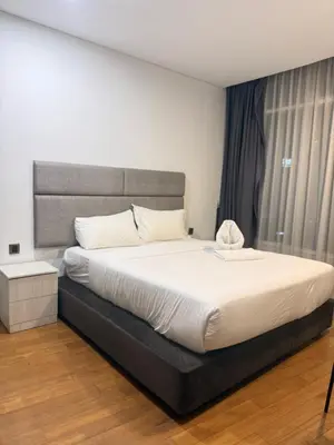 a bedroom with a large bed with white sheets at Vortex KLCC in Kuala Lumpur