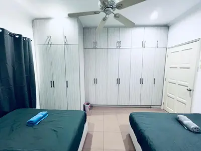 a bedroom with two beds and white cabinets at 9 Min KLCC 9KM Mid Valley Karaoke 30Pax 7Car in Kuala Lumpur