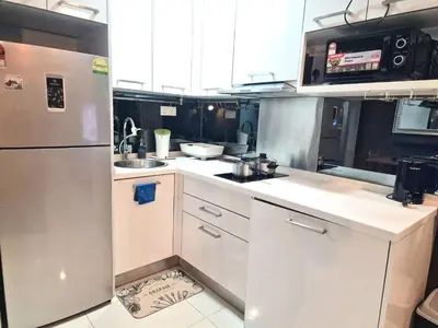 a kitchen with white cabinets and a stainless steel refrigerator at Summer suites klcc by Amna in Kuala Lumpur