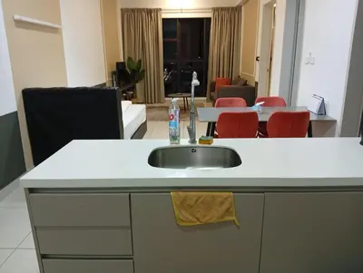 a kitchen with a sink and a living room at B&B at TRION KL in Kuala Lumpur