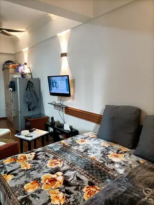 a living room with a bed and a tv at Cozy Suite City Central in Kuala Lumpur