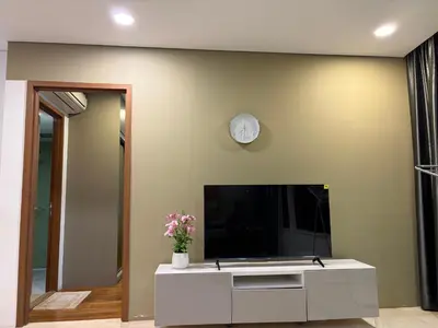 a living room with a tv on a wall at sky suites by towerview in Kuala Lumpur