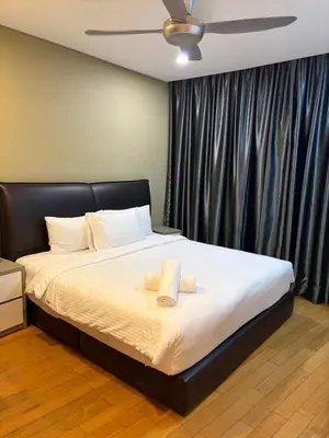 a bedroom with a bed with two towels on it at sky suites by towerview in Kuala Lumpur