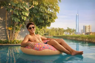 a man sitting on an inflatable ball in a swimming pool at Trion Kuala Lumpur in Kuala Lumpur