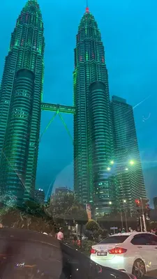 two tall skyscrapers in a city at night at VORTEX SUITES KLCC By SKYLINE in Kuala Lumpur