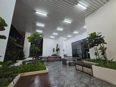 a lobby with benches and potted plants in a building at KLCC SERVICED Suites CHAMBERS in Kuala Lumpur