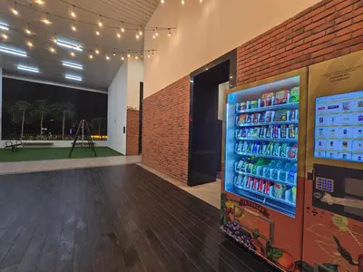 a soda vending machine in a room with a brick wall at KLCC SERVICED Suites CHAMBERS in Kuala Lumpur