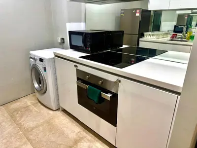 a kitchen with a stove and a washing machine at Vortex Suites Apartment Klcc in Kuala Lumpur