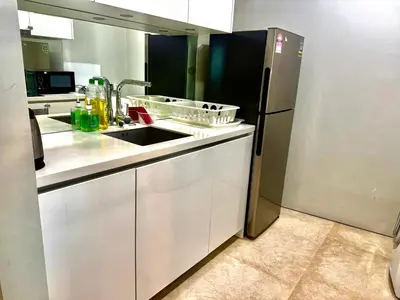 a kitchen with a sink and a refrigerator at Vortex Suites Apartment Klcc in Kuala Lumpur