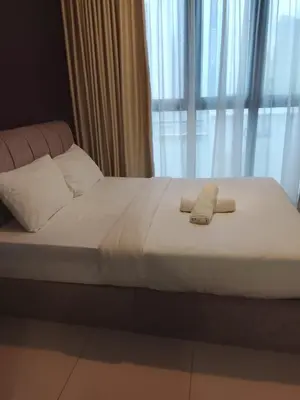 a bed with two towels on it with a window at Kuala Lumpur Majestic Suites KLCC in Kuala Lumpur