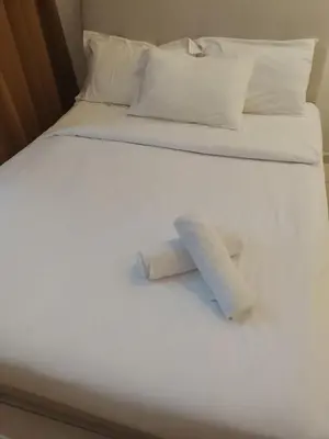 a bed with two pillows and two towels on it at Kuala Lumpur Majestic Suites KLCC in Kuala Lumpur