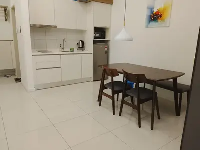 a kitchen with a wooden table and two chairs at Kuala Lumpur Chambers Suites KLCC in Kuala Lumpur