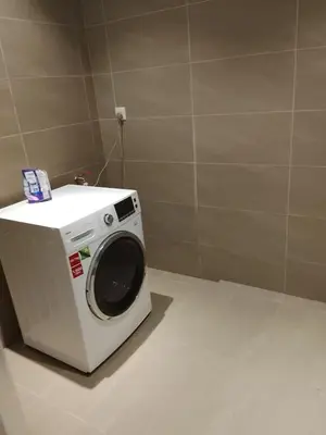 a washing machine is sitting in a bathroom at Quill Kuala Lumpur Suites KLCC in Kuala Lumpur