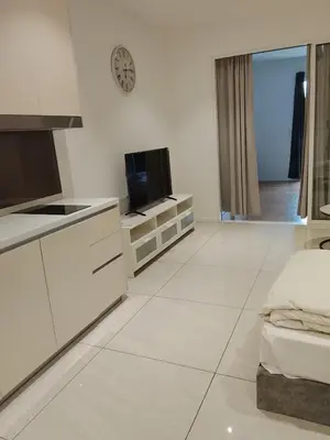 a kitchen with white cabinets and a tv in it at Quill Kuala Lumpur Suites KLCC in Kuala Lumpur