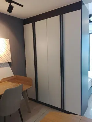 a dining room with white cabinets and a table at The Luxe Suites Colony Sky Pools in Kuala Lumpur