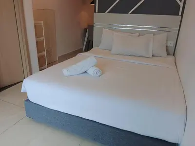 a white bed with a headboard and a pillow on it at The Luxe Suites Colony Sky Pools in Kuala Lumpur