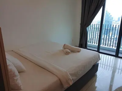 a bed with a towel on top of it with a window at The Luxe Suites Colony Sky Pools in Kuala Lumpur