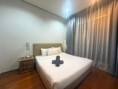 a bed with a black cross on top of it at Soho Suites KLCC by MIMI in Kuala Lumpur