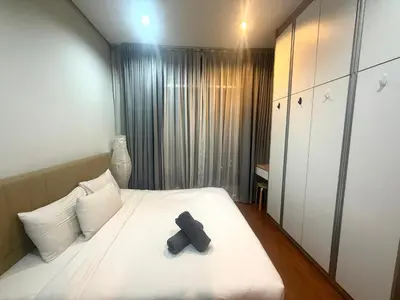 a bedroom with a bed with a teddy bear on it at Soho Suites KLCC by MIMI in Kuala Lumpur