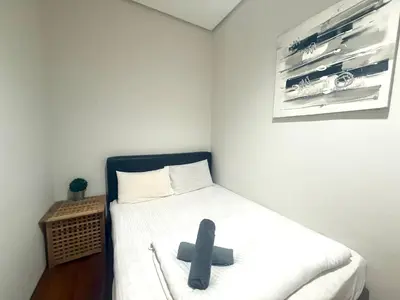 a small room with a bed with a black cross on it at Soho Suites KLCC by MIMI in Kuala Lumpur