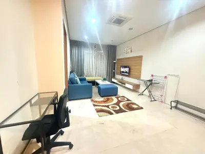 a living room with a blue couch and a television at Soho Suites KLCC by MIMI in Kuala Lumpur