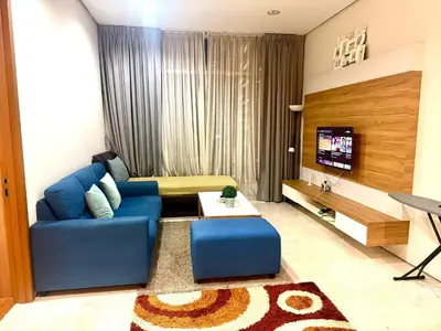 a living room with a blue couch and a tv at Soho Suites Klcc By Bukit Bintang in Kuala Lumpur