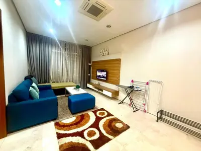 a living room with a blue couch and a tv at Soho Suites Klcc By Bukit Bintang in Kuala Lumpur