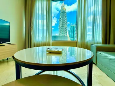 a living room with a glass table in front of a window at vortex suites apatment by sapporo in Kuala Lumpur